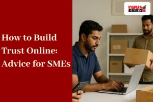 Trust Lanka | Three Sri Lankan small business workers in a modern workshop. A woman in a denim shirt is using her smartphone, a man in a navy polo shirt is working on a laptop, and another man in a brown shirt is carrying a cardboard box. A black delivery helmet and a sealed package are placed on the table, with more boxes stacked on shelves in the background.