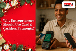 A smiling Sri Lankan entrepreneur sits at a shop counter holding a POS machine while a customer makes a card payment. A QR payment stand and smartphone are also visible. The left side of the image features a festive red background with Christmas decorations and the text “Why Entrepreneurs Should Use Card & Cashless Payments?” along with the Vyapara.lk logo in the top-right corner.