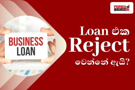 Business loan | Graphic promoting a guide on why business loan applications get rejected, featuring hands holding a "Business Loan" card against a financial documents background with the Sinhala headline asking why a loan application is rejected.